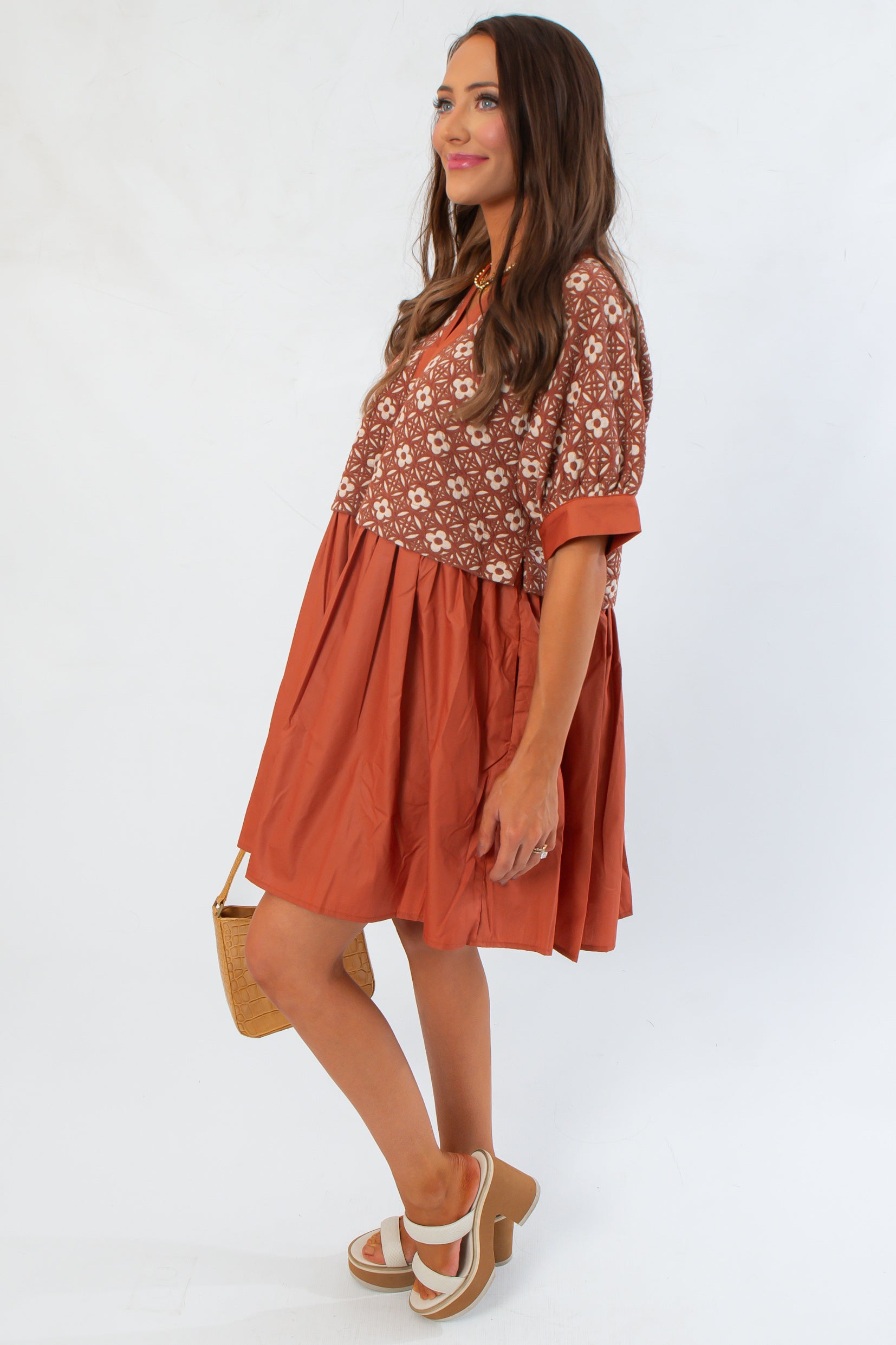 Side view of Chateau Chic Rust Embroidered Babydoll Dress showing relaxed fit and short cuffed sleeves for fall styling.