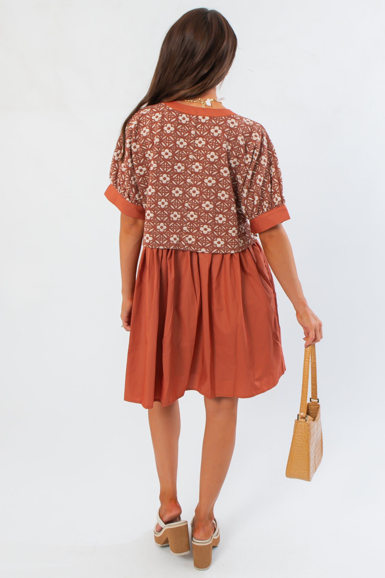 Back view of Chateau Chic Rust Embroidered Babydoll Dress highlighting embroidered bodice and gathered skirt for seasonal wear.
