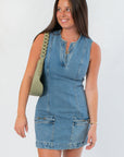 Steve Madden Denim Dress - Averi Blue Denim | Fashion. Close-up of sleeveless blue denim dress featuring a front slit neckline and zippered pockets.