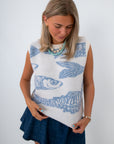 woman looking down wearing sleeveless knit fish sweater with blue fish pattern