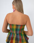 Side profile of woman in plaid strapless top with pink earrings