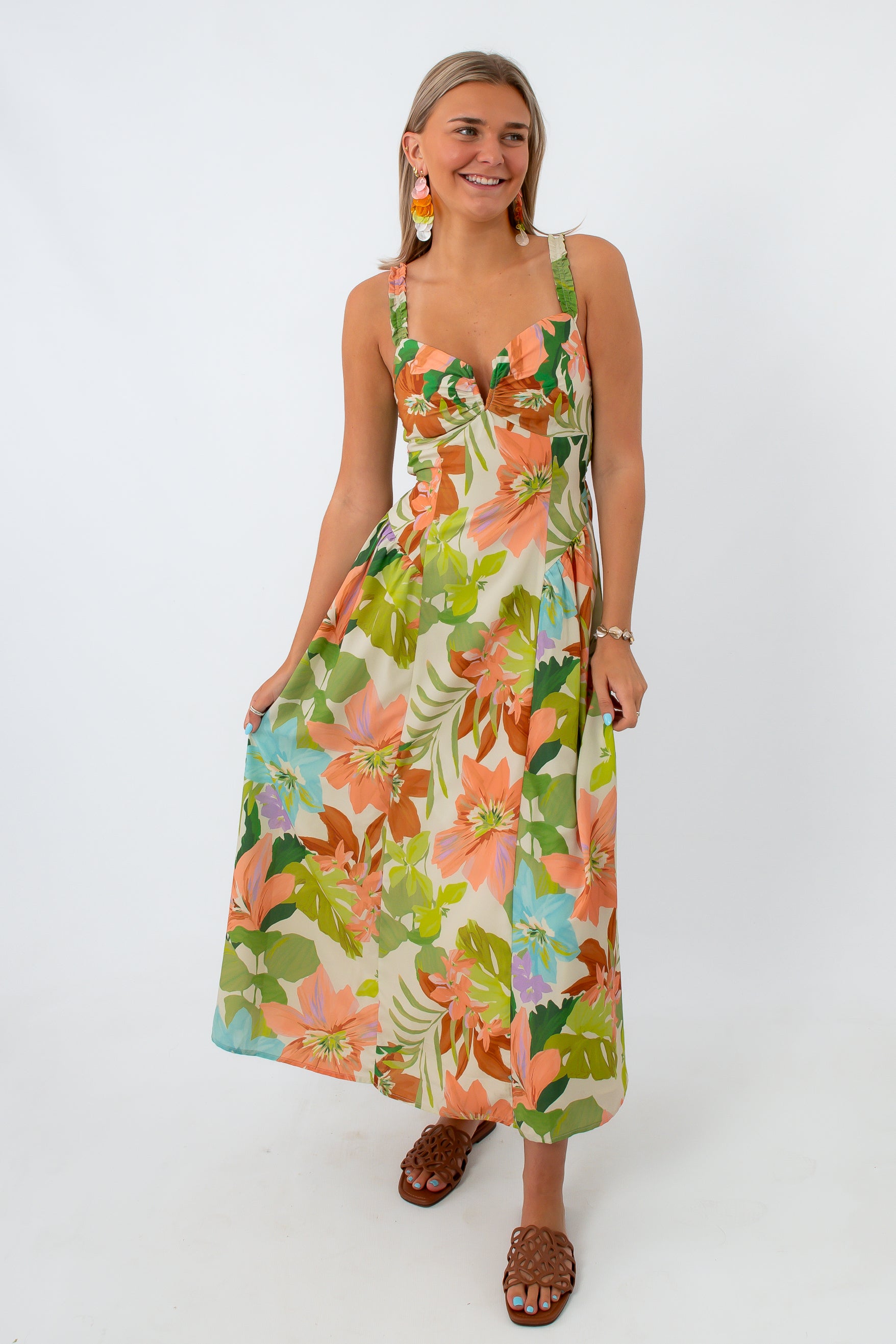 Close-up of woman smiling in floral maxi dress with colorful earrings