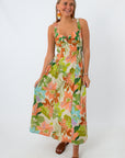 Close-up of woman smiling in floral maxi dress with colorful earrings