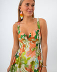 Side view of woman in tropical floral maxi dress with colorful earrings