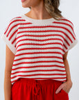 Woman wearing a red and white striped top with red pants on a plain background