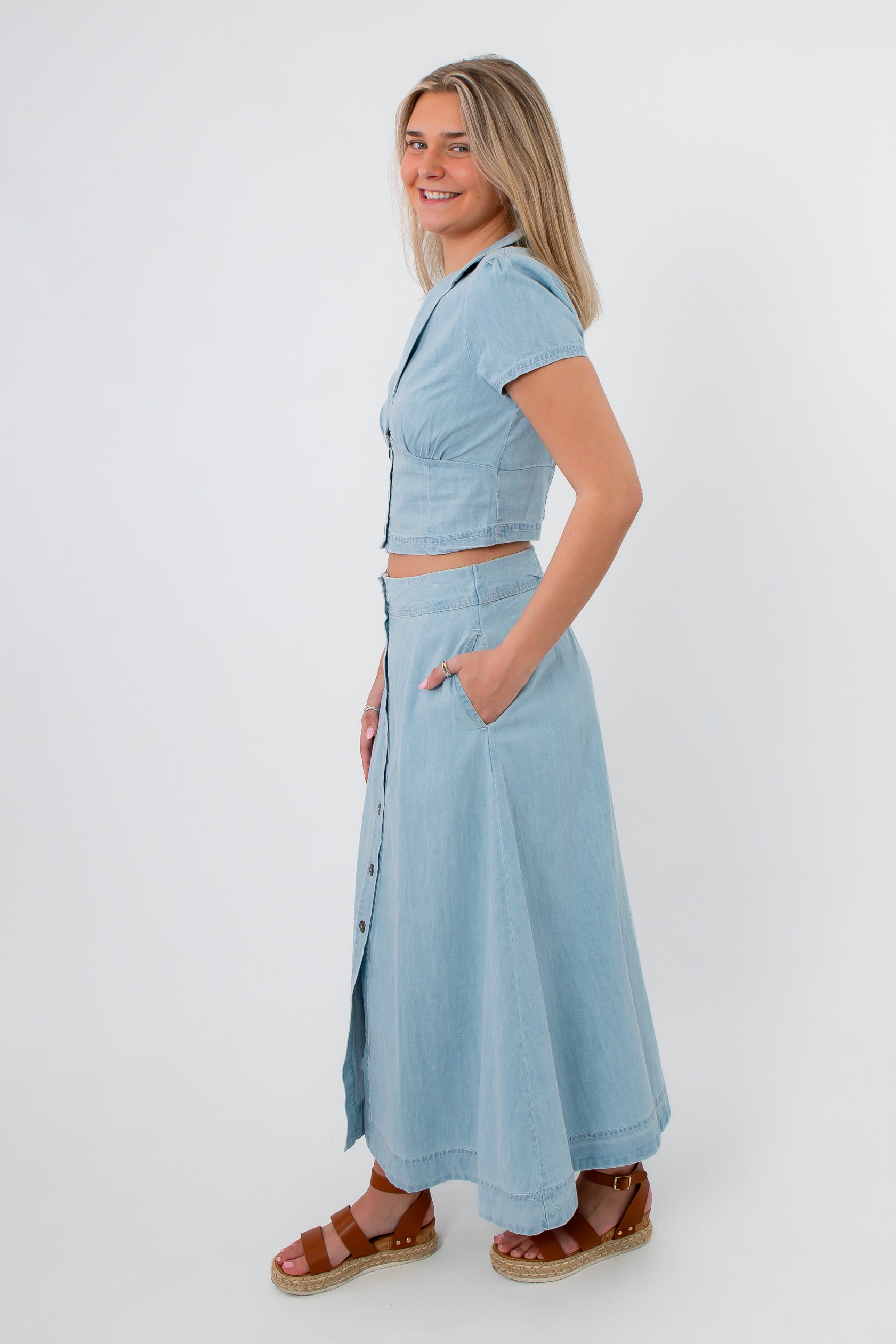 Back view of light blue denim cropped top and maxi skirt set with button details, casual spring outfit