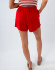 Person wearing a red skirt and striped top on a white background