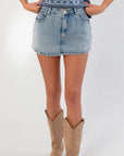 Close-up of Dukes Up Light Denim Mini Skort showing high waist and light wash denim, ideal for casual fall looks with boots or sweaters.