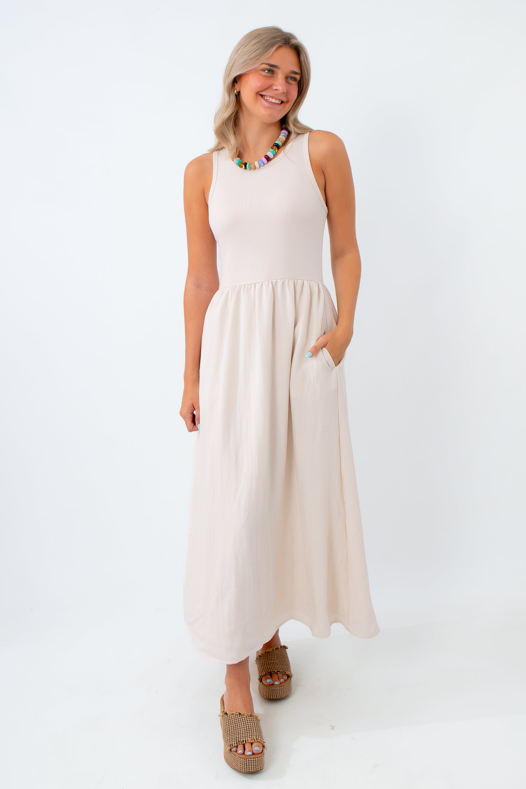 Woman wearing a white sleeveless dress on a white background
