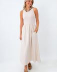 Woman wearing a white sleeveless dress on a white background
