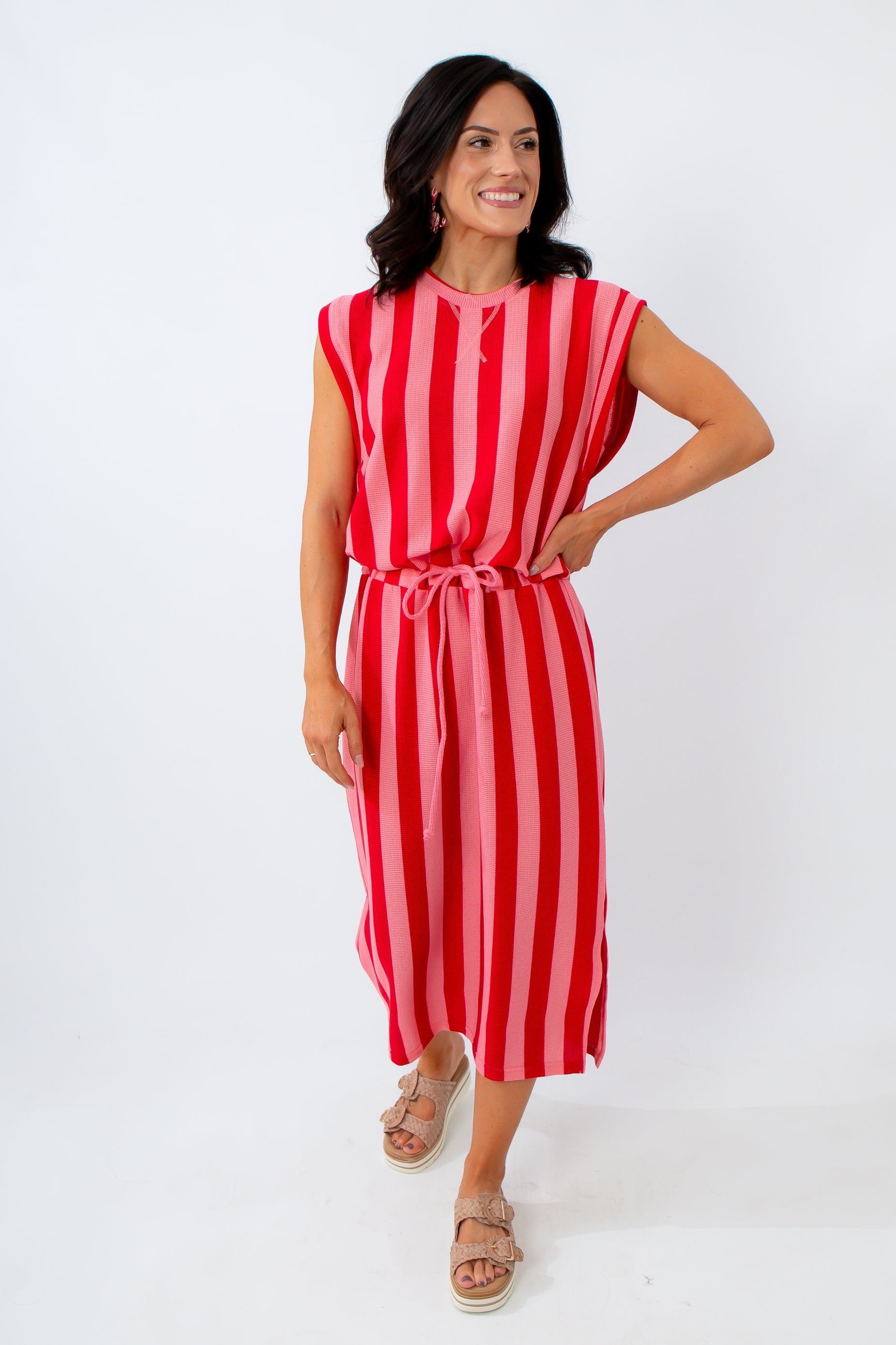 Woman wearing a red and white striped dress on a white background