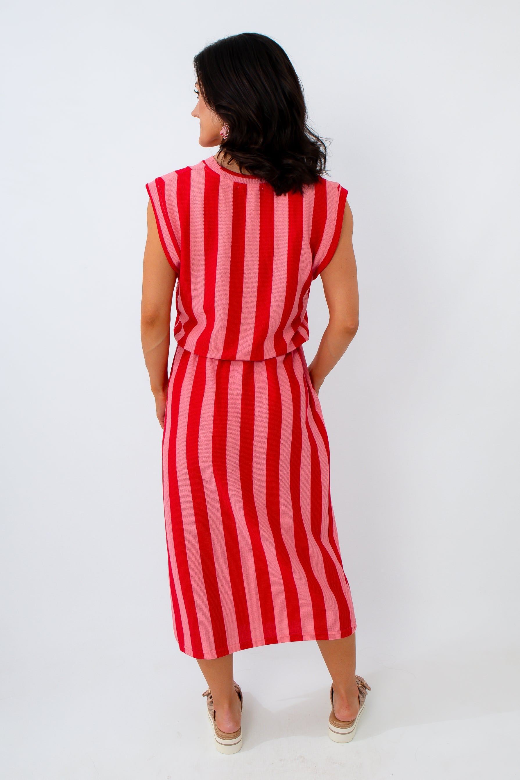 Woman wearing a red and white striped dress on a white background