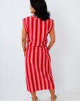 Woman wearing a red and white striped dress on a white background