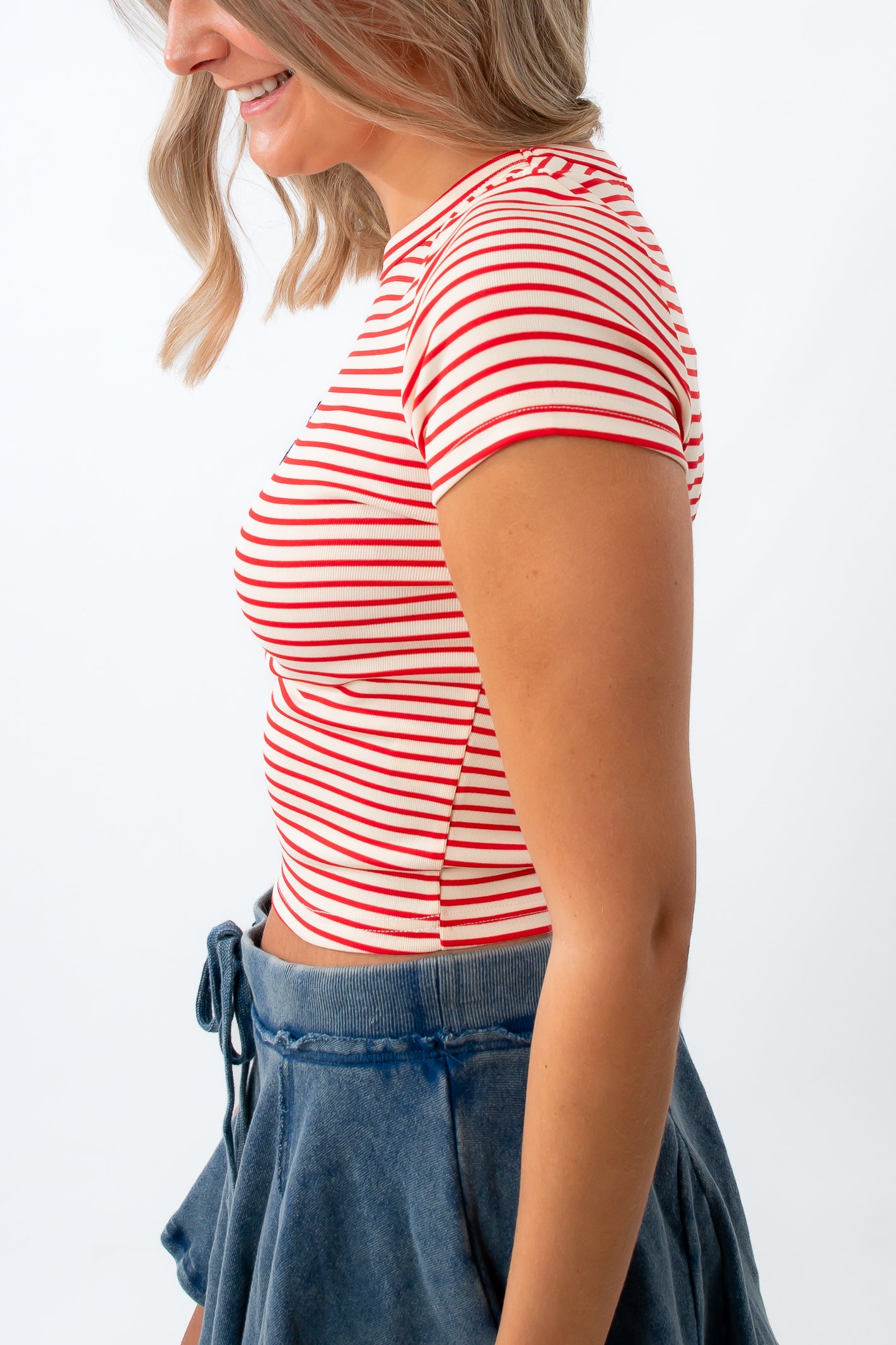 Woman wearing a red and white striped shirt with a white background
