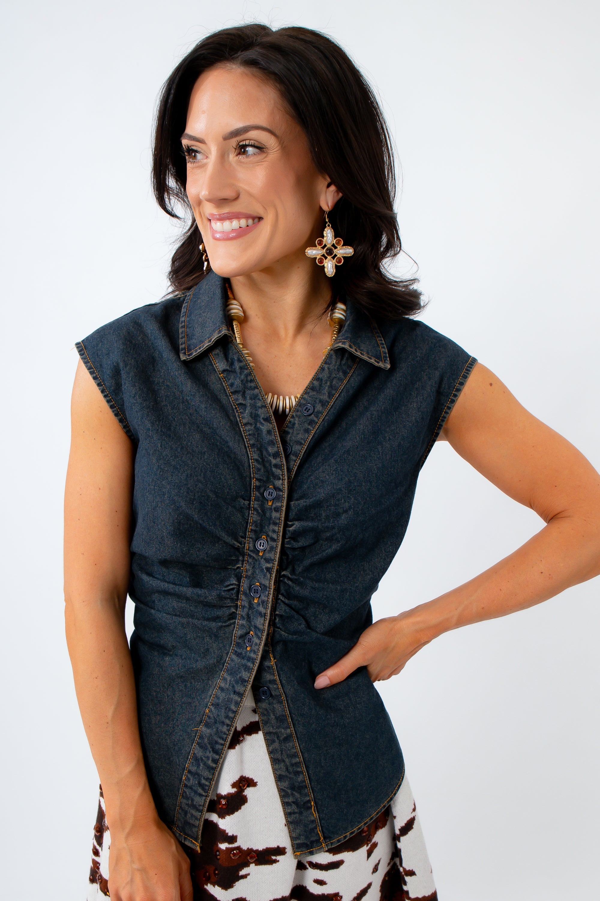 Woman wearing a denim vest styled for a summer country concert on a white background