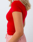 Person wearing a red top and striped skirt on a white background