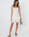 White mini dress with pleated hem, sleeveless, square neckline, stylish for parties and events
