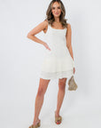 Front view of white pleated mini dress with square neckline, perfect for summer occasions