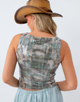 Woman wearing a patterned top and wide-brimmed hat on a white background