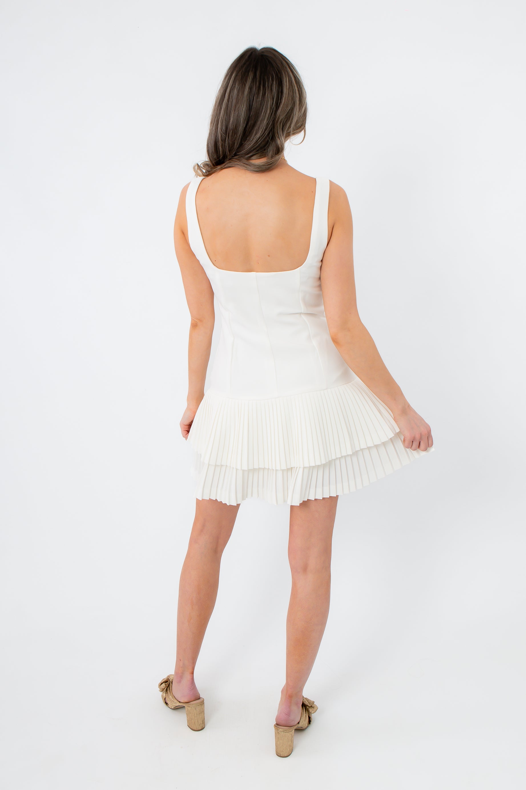 White pleated mini dress with ruffle hem for women