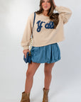 Denim Bubble Skort - Mini Skort worn with 'Y'all' sweatshirt and tan boots, showcasing high waist and playful bubble silhouette.