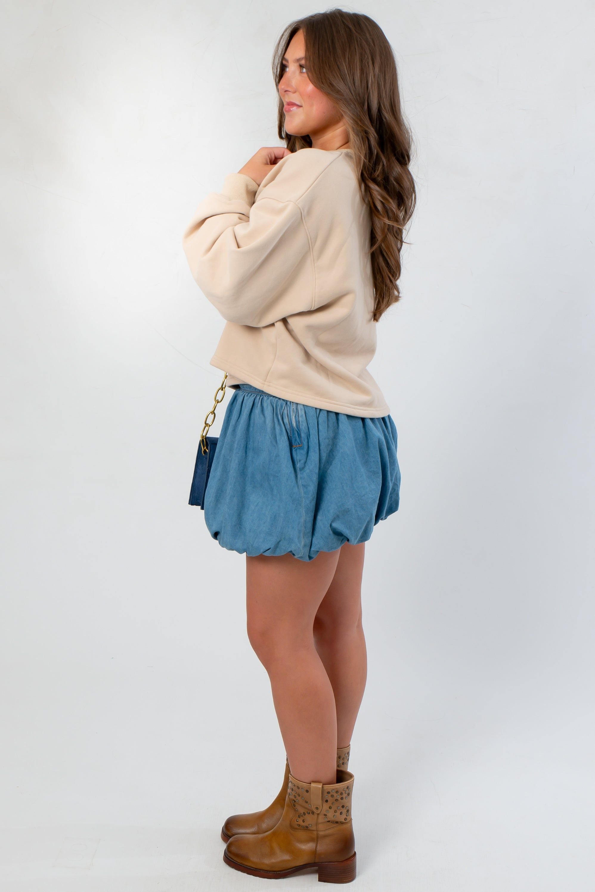 Side view of Denim Bubble Skort - Mini Skort with elastic waistband and voluminous bubble hem, styled for a relaxed fall outfit.