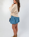 Side view of Denim Bubble Skort - Mini Skort with elastic waistband and voluminous bubble hem, styled for a relaxed fall outfit.