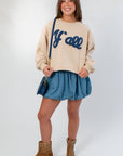 Front view of Denim Bubble Skort - Mini Skort paired with casual sweatshirt and boots, highlighting its high waist and bubble hem.