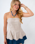 Woman wearing a strapless top with a blue hem on a white background