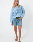 Light blue oversized crewneck sweatshirt with 'Coast' and sailboat graphic, casual women's fashion