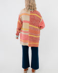 Back view of Iris Orange Stripe Open Cardigan – Features colorful horizontal stripes and relaxed silhouette for a casual, stylish outerwear look.