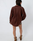 Women’s oversized brown button-up shirt with long sleeves, back view