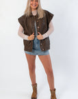 Model wearing Bittersweet Chocolate Brown Faux Leather Oversized Vest – Modern Style with casual boots and denim skirt, ideal for streetwear layering.