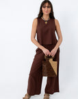 Back view of women in relaxed brown linen trousers with side pockets, styled with casual sandals