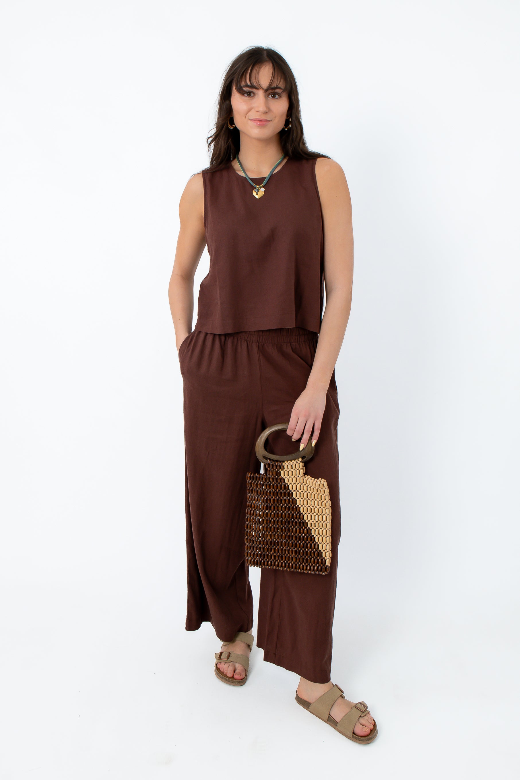 Women wearing Z Supply Chocolate Cherry Scout Linen Pant in relaxed fit, brown linen fabric, paired with beige sandals and jewelry