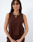 Front view of brown linen sleeveless top with relaxed fit and round neckline, paired with matching linen pants