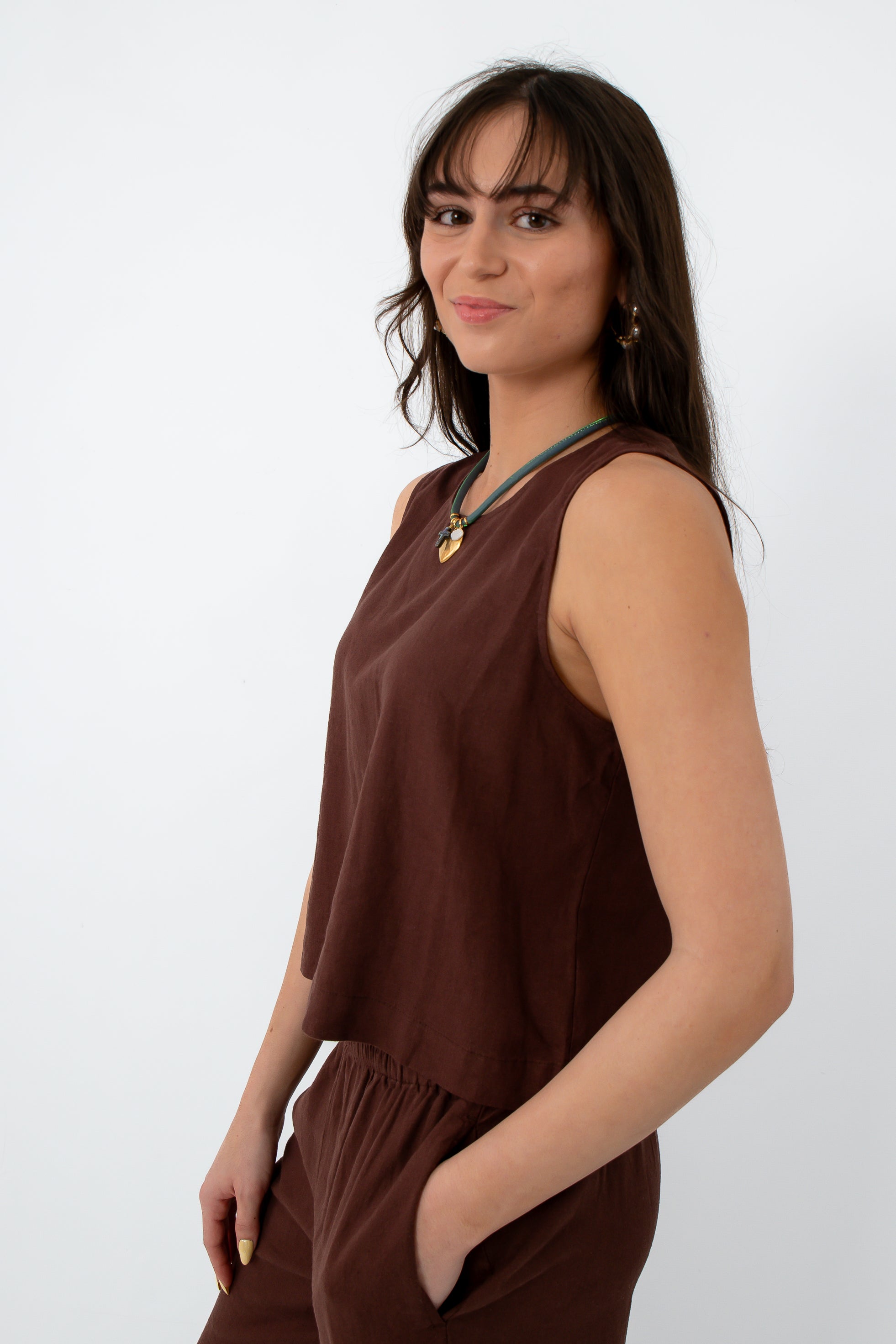 Brown linen tank top with sleeveless design, relaxed fit, and round neckline, styled with jewelry