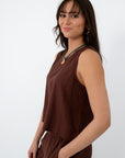 Brown linen tank top with sleeveless design, relaxed fit, and round neckline, styled with jewelry