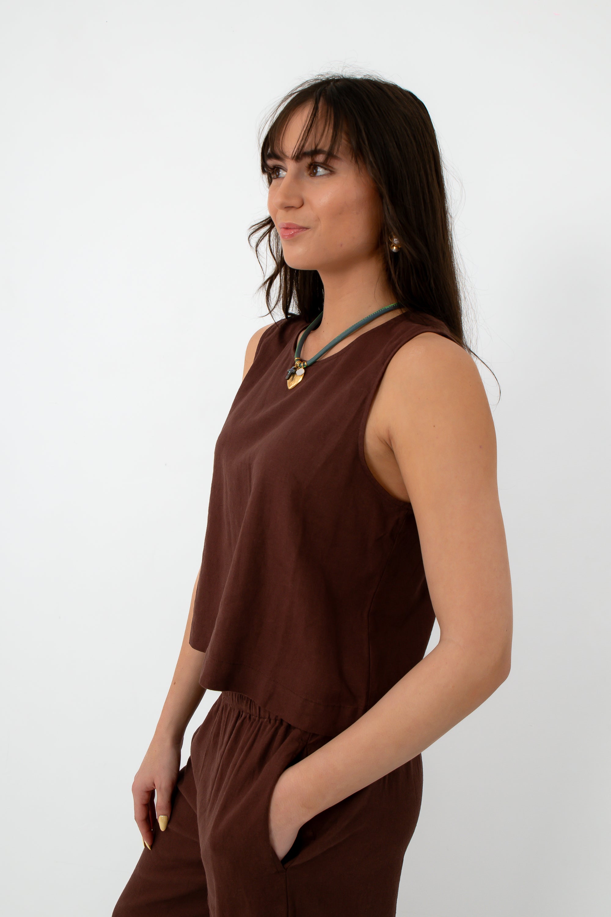 Back view of brown linen tank top with button closure at neckline, styled with jewelry and matching linen pants