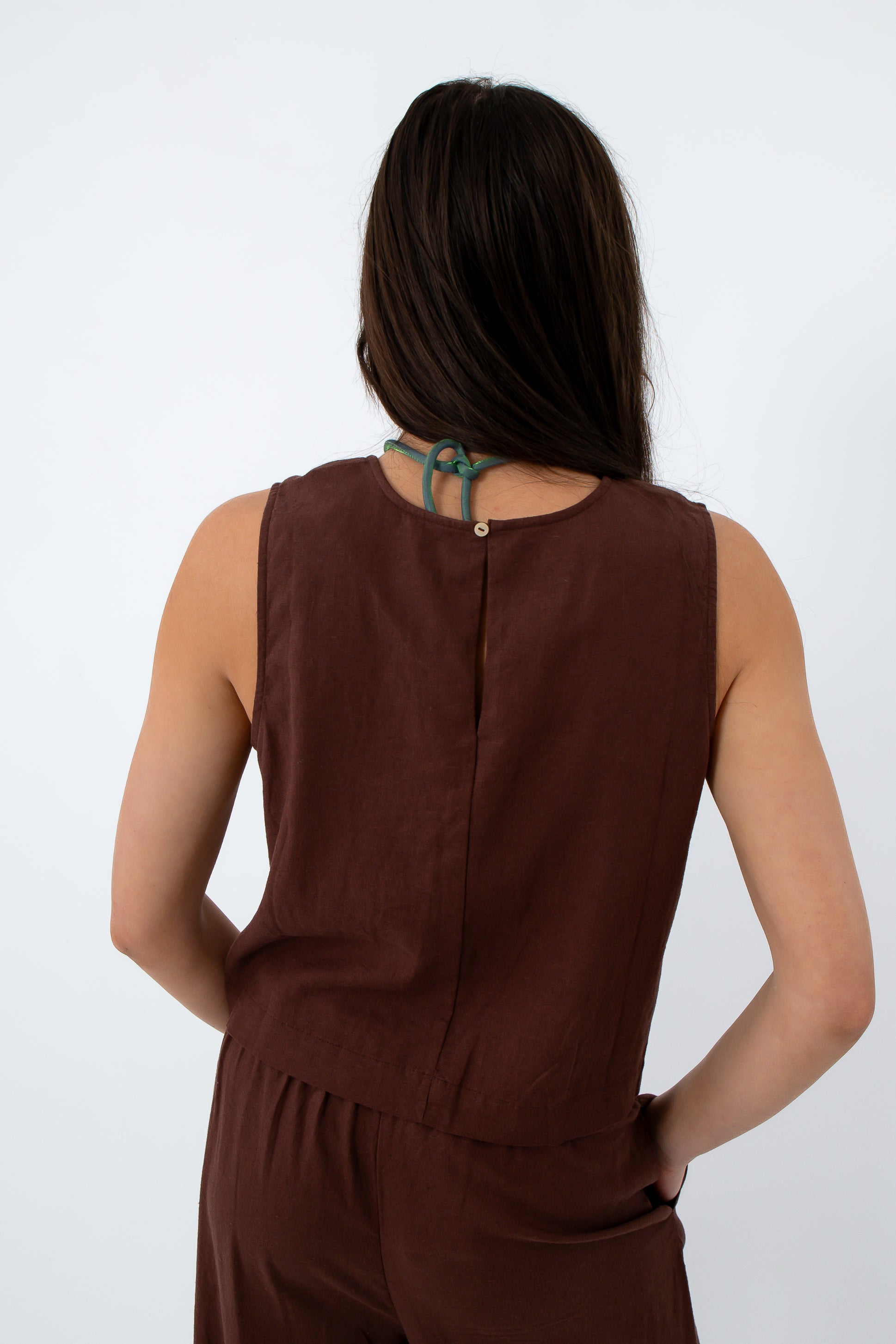 Back view of brown linen tank top with sleeveless design and relaxed fit