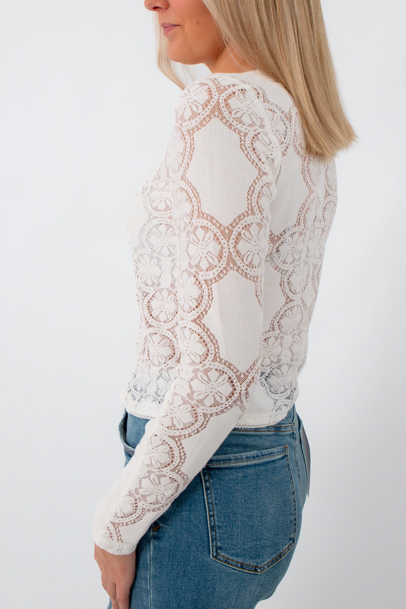 Back view of white lace blouse with floral embroidery and round neckline