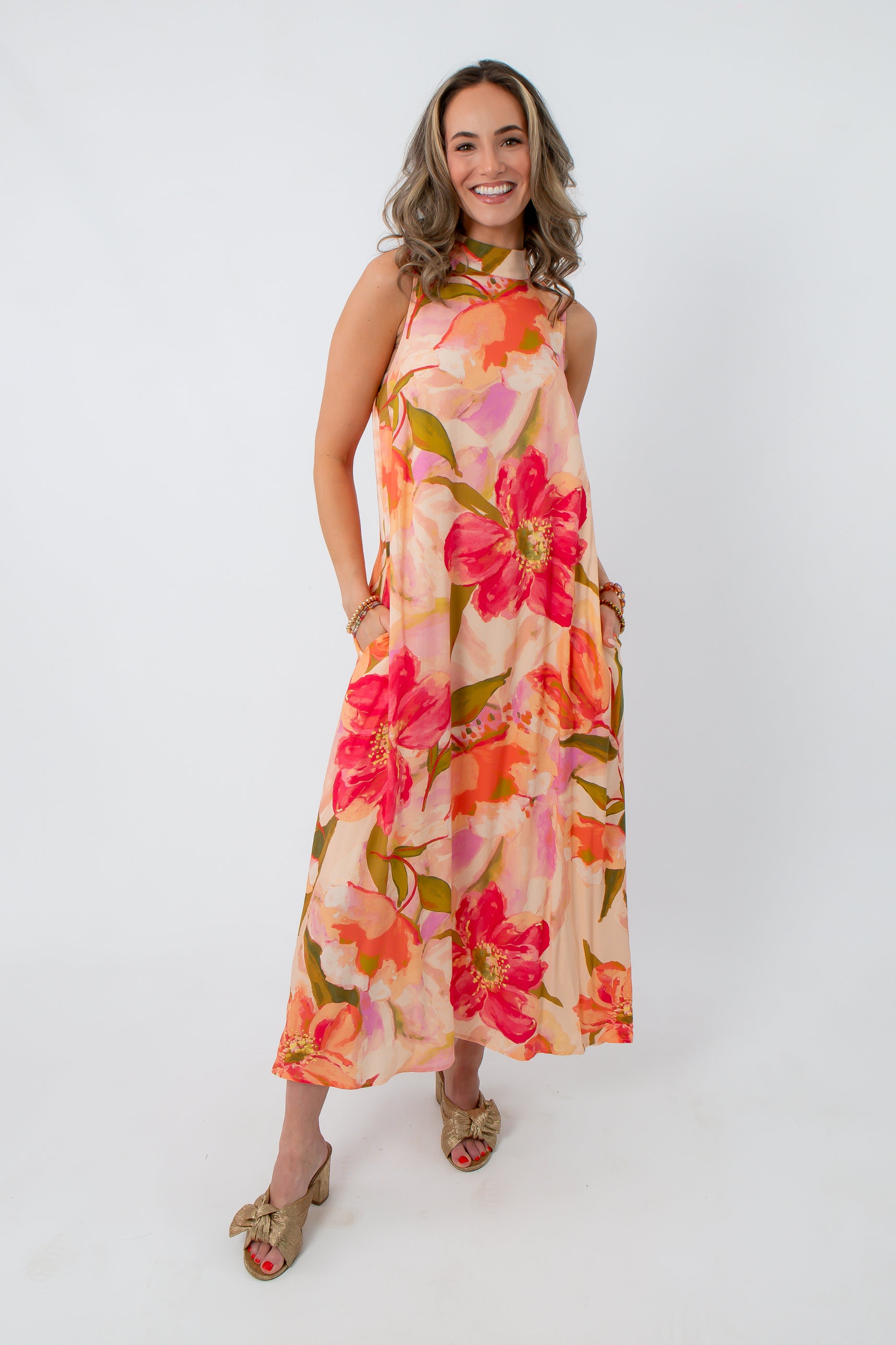 Side view of woman in floral maxi dress with large flower pattern, showing dress length and flowy style, wedding guest attire