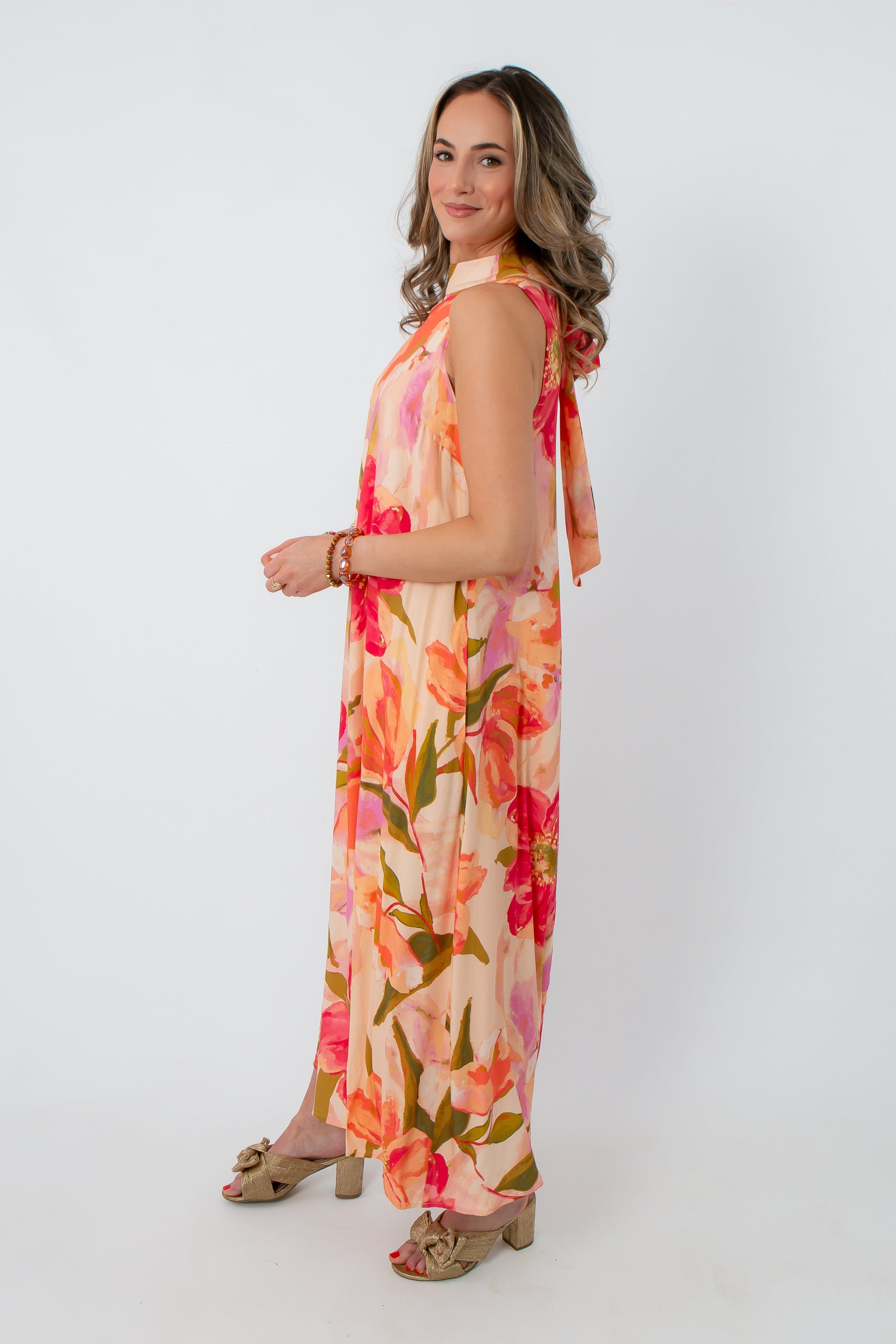 Back view of woman in floral maxi dress with bow detail on shoulder, elegant floral print, suitable for garden parties and celebrations