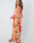 Back view of woman in floral maxi dress with bow detail on shoulder, elegant floral print, suitable for garden parties and celebrations