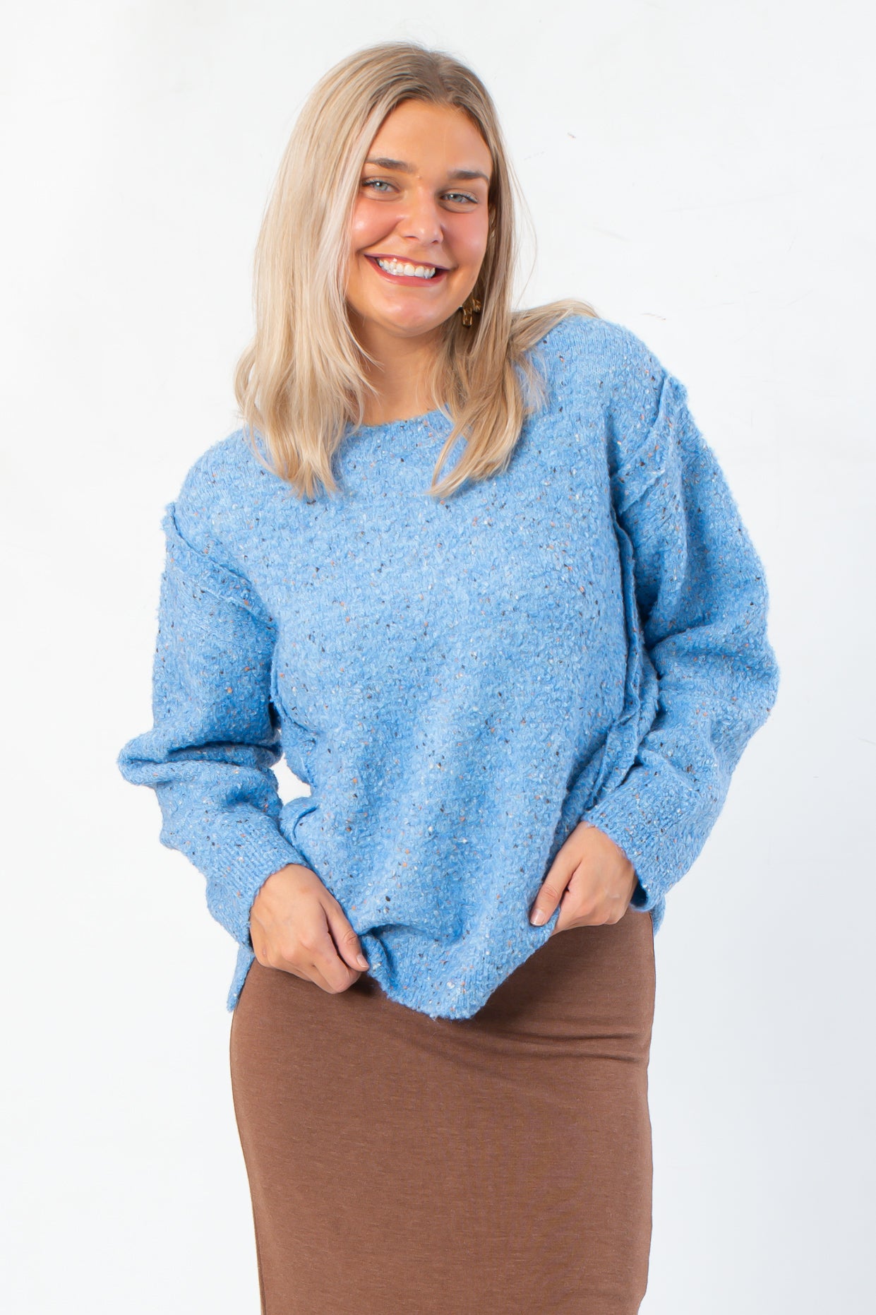 Lorelai Blue Marbled Round Neck Sweater with cozy texture and inverse stitching, styled with a brown skirt for a casual fall look.