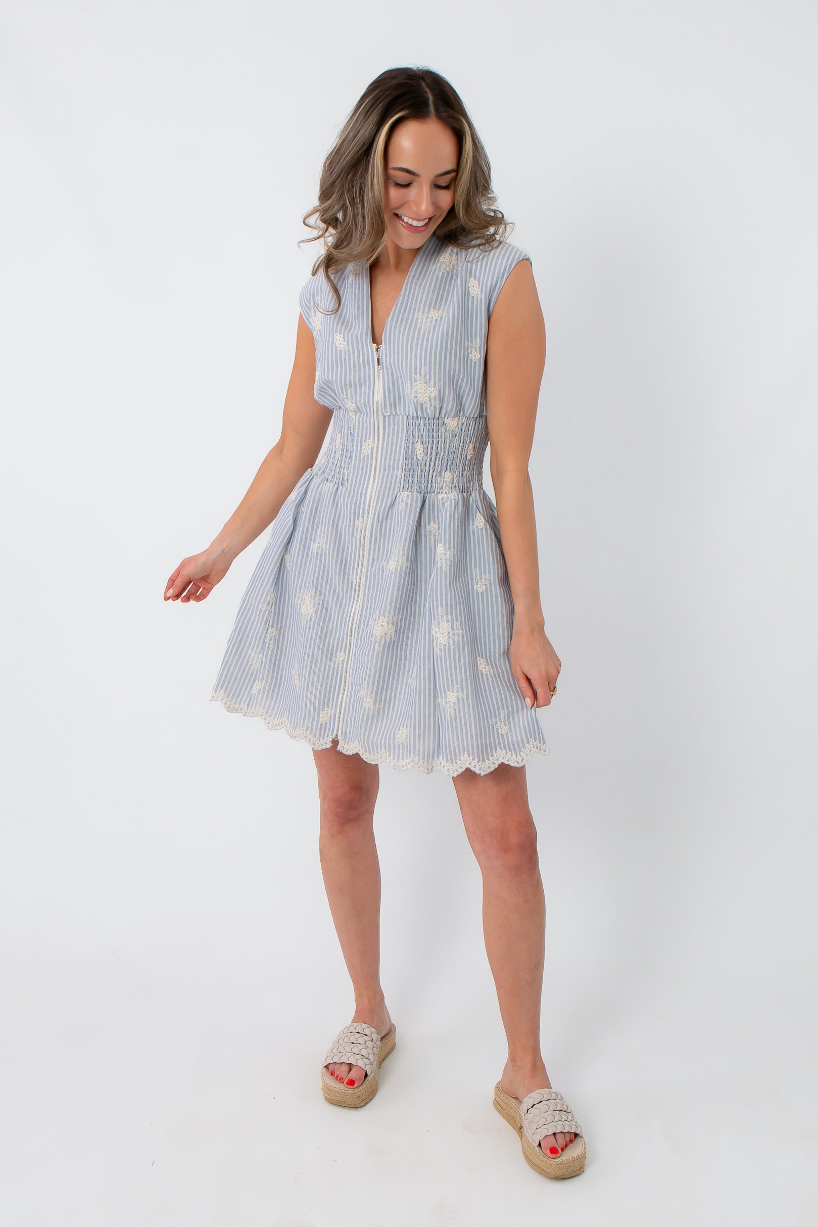 Back view of blue and white embroidered mini dress with scalloped hem