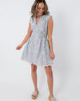 Back view of blue and white embroidered mini dress with scalloped hem
