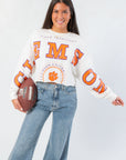 Clemson Phipps Cropped Long Sleeve Top with bold orange lettering and raw hem, styled for game day with a football prop.