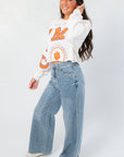 Side view of Clemson Phipps Cropped Long Sleeve Top showing relaxed fit and trendy cropped cut, paired with wide-leg jeans.