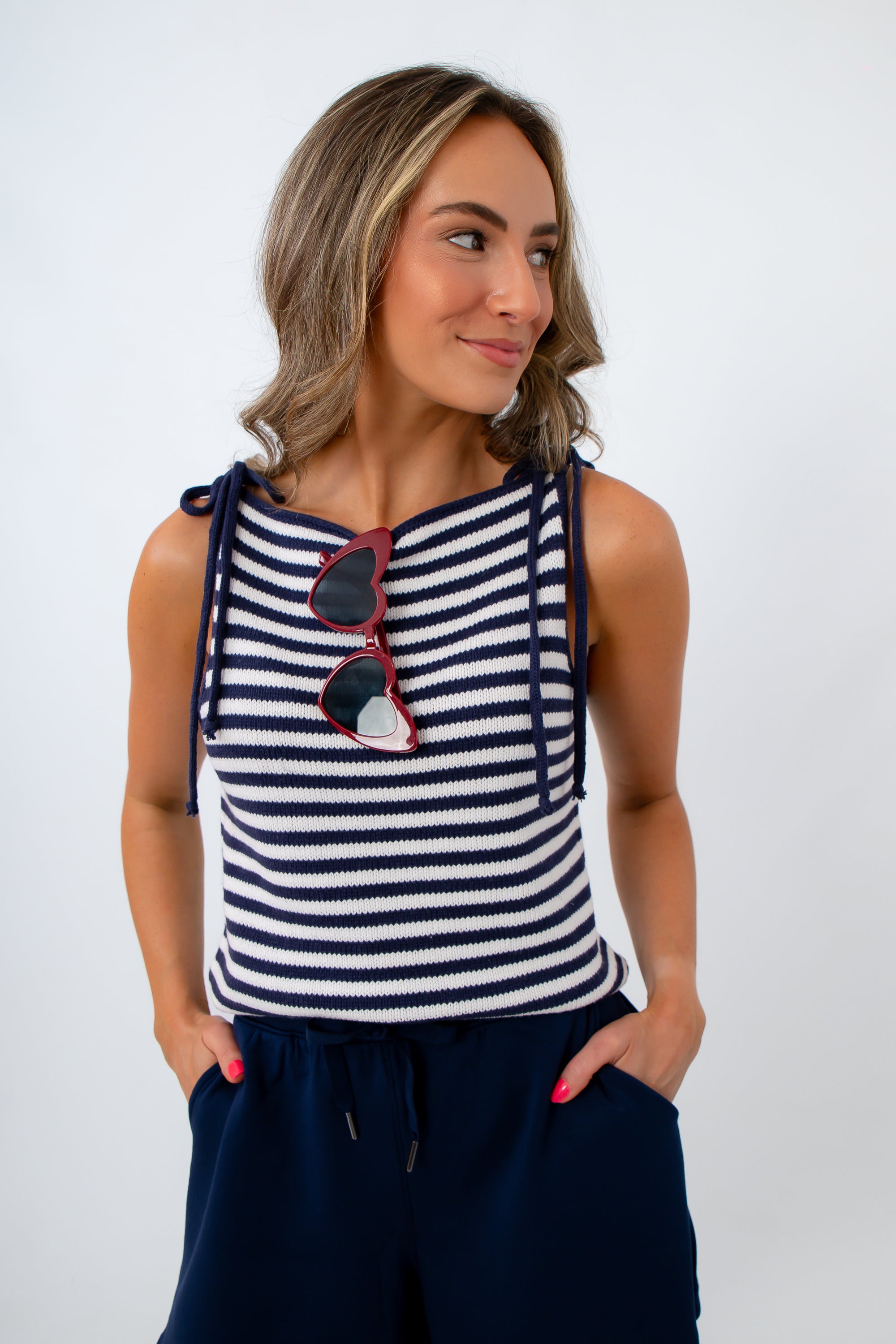 Woman wearing a navy and white striped sleeveless top with red sunglasses for a casual 4th of july outfit